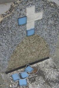 Photo d'une tombe, où six carreaux de faïence bleue figuraient une croix; quatre sont tombés